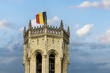 Top section of  the belfry a historic stone tower featuring a crenellated parapet and decorative pinnacles in Bruges, Belgium