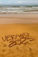 Rodiles Beach in Villaviciosa, Spain, under cloudy weather with soft waves, wet sand, and a calm, moody coastal atmosphere.
