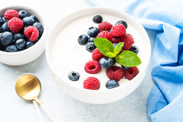 Yogurt with fresh berries in white bowl.