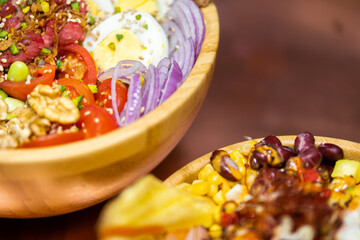 Poke bowl colorata con ingredienti freschi e tropicali in ciotola di legno