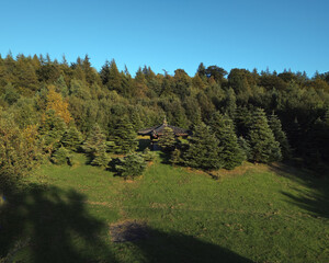 Top view of a small wooden Korean-style shrine, war memorial, is in the centre surrounded by trees. West Lothian, Scotland