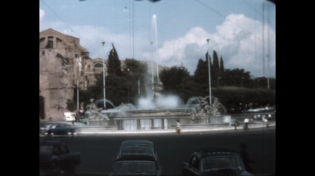 Fountain of the Naiads 1964 - Cars and people pass by the Fountain of the Naiads in the Piazza della Repubblica in Rome, Italy, 1964.