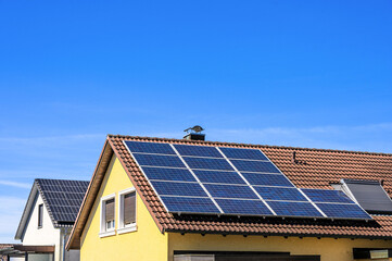 Naklejka premium Solaranlagen auf Hausdächern vor blauem Himmel