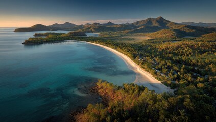 A tranquil, coastal bay with a pristine white sand beach, framed by lush green hills and a calm, turquoise ocean, captured from a high-altitude perspective.