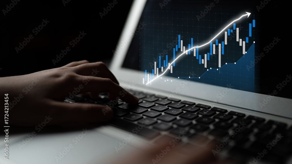 Aufkleber close-up of a hand using a laptop keyboard, focused on a digital graph displaying upward trends in f