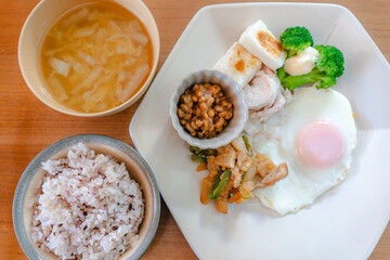 Healthy Japanese breakfast with natto, egg, chicken breast and vegetables

