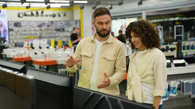 Couple choosing a new discounted tv in electronics store