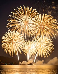Golden fireworks burst over water at night