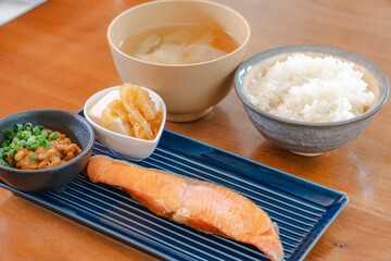 Japanese breakfast with grilled salmon, natto, tofu, miso soup and rice
