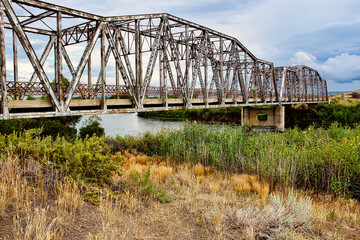 Obraz premium Late Summer View of the Steel Old Government Bridge Standing up on the Bank of the North Platte River in Southern Wyoming near Casper.