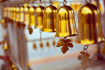 Many golden bells in a row in a buddhist temple in Bangkok, Thailand