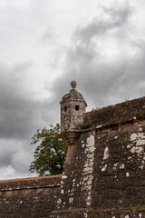 Bartizan, a small overhanging turret projecting from the walls of Valença Fortress in Portugal, stands tall against a backdrop of cloudy sky, showcasing historical military architecture