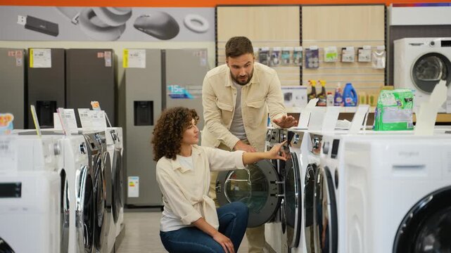 Couple choosing washing machine in electronics store on Black Friday