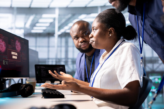 Server hub staff members protecting hardware from hacker attack stealing sensitive info. Team of data center employee doing brainstorming to erase virus after seeing security breach alert on monitor - Powered by Adobe