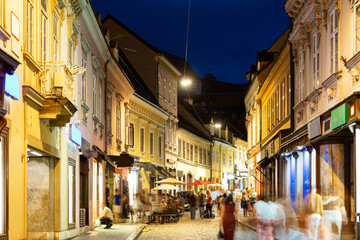 Fototapeta premium Evening pedestrian street Tkalciceva between old two- and three-story houses, paving stones, street cafes and walking pedestrians ..