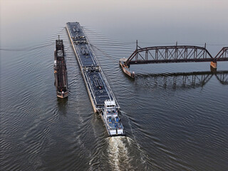 Set of liquid cargo barges being pushed through the narrow opening of the railroad swing bridge at Sabula Iowa