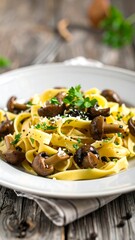 Creamy pasta with mushrooms.  Fresh fettuccine pasta, coated in a light sauce, with sauteed brown mushrooms and sprinkled with black pepper.  Parsley garnish. Served on a white plate