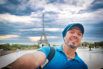 Turista disfrutando de la Torre Eiffel en París, con boina azul parisina y sonrisa alegre. © ismel leal