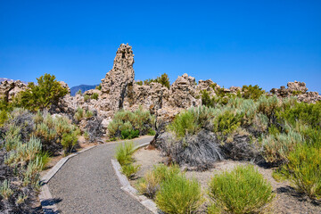 Tufa Formations and Walking Path with Native Brush Under Blue Sky