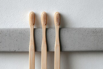 Three bamboo toothbrushes on a grey surface