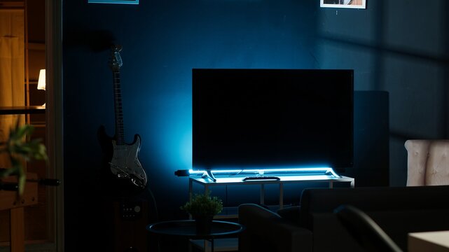 Urban apartment with a stylish home office setup with a wooden desk, house plants and a TV creating a cozy modern interior design. Spacious, creative and perfect for a homey lifestyle.