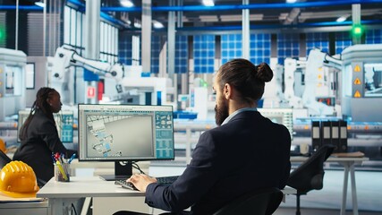 Engineer in photovoltaics factory drinks coffee at PC and diagnoses malfunctioning systems. Man enjoying beverage in solar panels manufacturing plant, reducing downtime, camera A