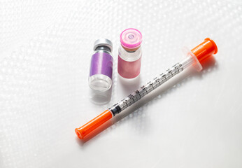 Close up of Vial with Injectable Compounds Next to Syringe