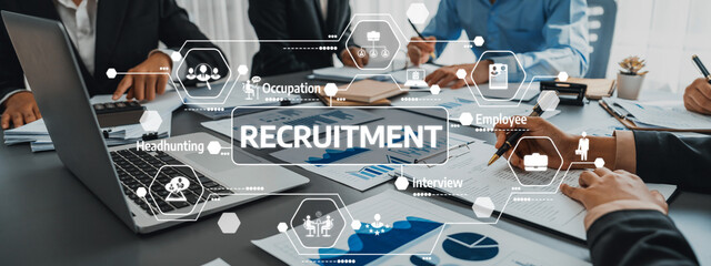 Engaging business meeting highlighting recruitment strategies with professionals collaborating over documents, showcasing technology and innovative ideas in a modern office setting. Amity