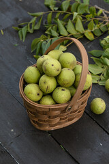 Black walnuts in a basket on rustic background, organic nuts harvest