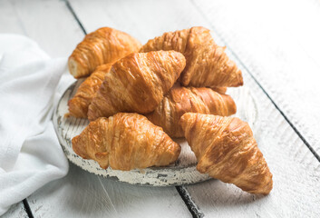 Fresh croissants on white wooden boards, flaky buttery pastry, rustic breakfast