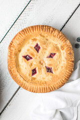 Cherry and blueberry pie on white wooden boards, homemade rustic dessert