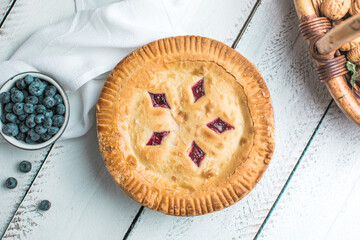 Cherry and blueberry pie on white wooden boards, homemade rustic dessert