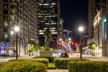 Statue of Atlanta Chief with Millennium Gate monument lit up at night in background