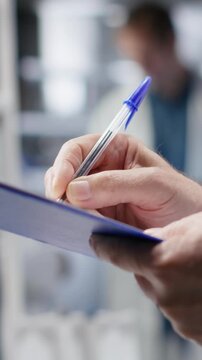 Vertical Video Close up of handwriting notes on clipboard for research study results in a chemistry lab, researcher conducting an experiment for biochemistry, nanotechnology and diagnostics. Camera B.
