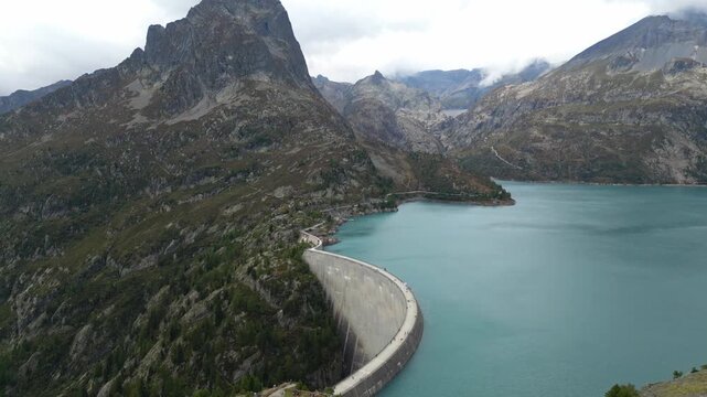 Aerial view of Emosson Dam in Finhaut, Switzerland, with the upper Vieux Emosson Dam visible in the background, surrounded by dramatic alpine mountains.