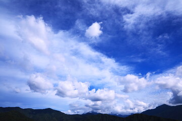 山の上空に湧き上がる雲