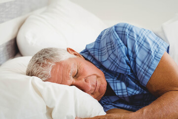 White duvet and pillows lying on bed under soft morning light with blue plaid, copy space