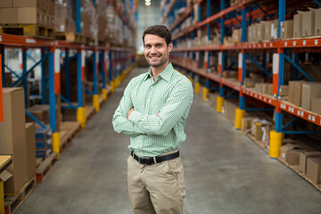 Shelving units are lining warehouse aisle and holding stacked cardboard boxes under overhead lights