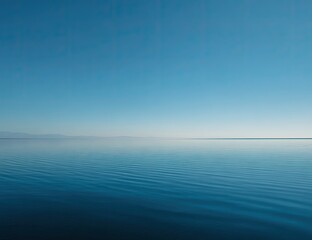 Obraz premium Calm, expansive body of water meets a clear, vast sky