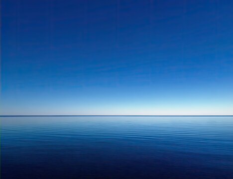 Tranquil expanse of a vast, serene blue ocean meeting a cloudless blue sky