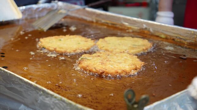 市場の屋台で緑豆チヂミを焼いているシーン