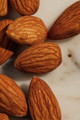 whole, raw almonds on white marble