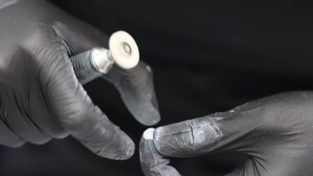 Macro shot of dentist using rotary handpiece with round brush attachment to polish dental veneer. Concept of cosmetic dentistry, CAD/CAM, and smile design.