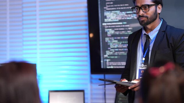 A confident man gives a presentation about AI and technology. He stands in front of a big screen showing computer code, explaining his new invention to the audience at a conference.