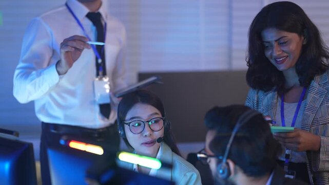 A team of engineers call center in a Network Operations Center collaborates on a critical alert, with a lead engineer guiding them through system diagnostics on a late night shift.