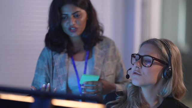 In a bustling all day call center, a diverse team woman and male of customer service agents with headsets collaborates while a manager supervises, providing multilingual support to global clients.