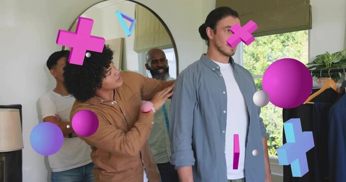 Curly-haired tailor stepping up to client measuring chest to hips using tape for fashion fitting