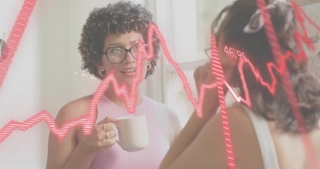 Two women sharing marketing tips while sipping mug in kitchen sparking pulsing red graph overlay - Powered by Adobe