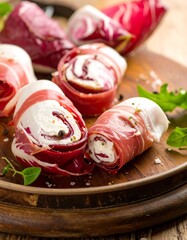 Colorful rolls of creamy cheese and red leaf, garnished with herbs and spices