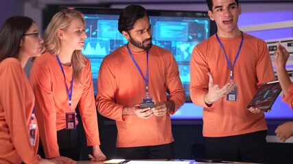 A data analytics team in a command center reviews a live data dashboard. They are collaborating on a strategy, analyzing key performance indicators and market intelligence data.
 - Powered by Adobe